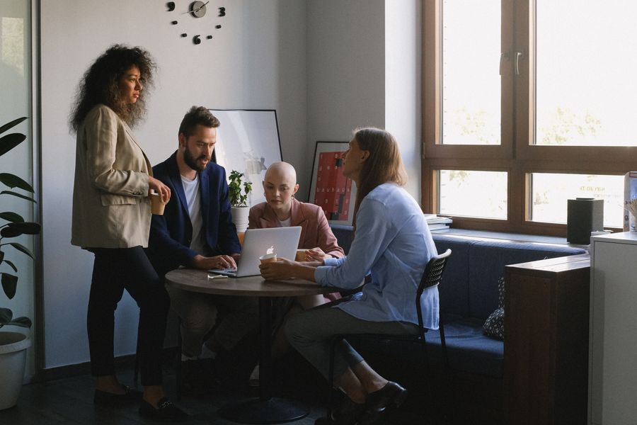 Colleagues collaborating around a laptop